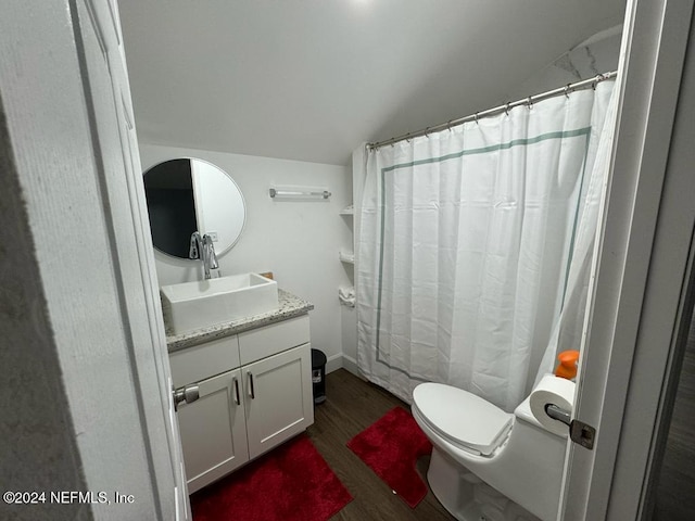 bathroom featuring hardwood / wood-style floors, vanity, vaulted ceiling, a shower with shower curtain, and toilet