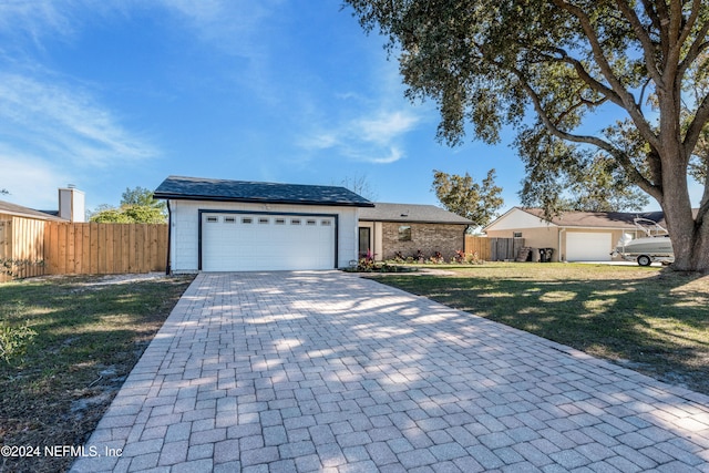 ranch-style home with a garage and a front yard