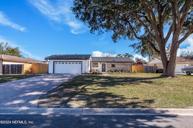 ranch-style home featuring a garage and a front lawn