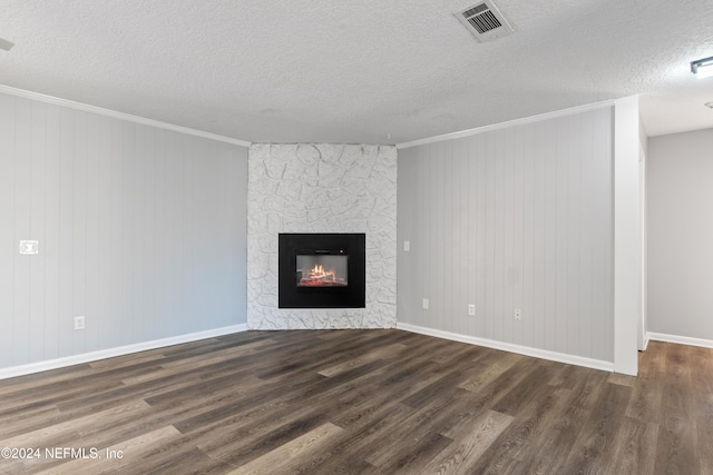 unfurnished living room featuring a stone fireplace, dark hardwood / wood-style flooring, and ornamental molding