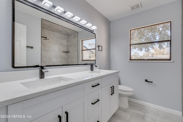 bathroom featuring tile patterned flooring, vanity, toilet, and a wealth of natural light