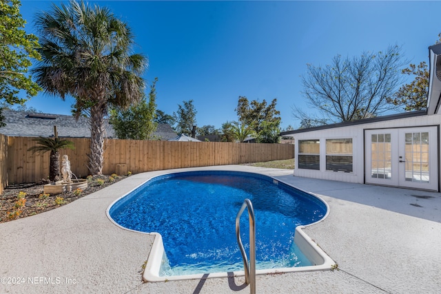 view of pool with french doors and a patio