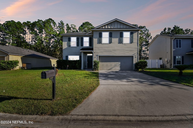 front of property with a garage and a lawn