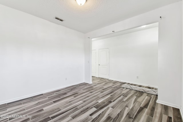 empty room featuring hardwood / wood-style floors and a textured ceiling