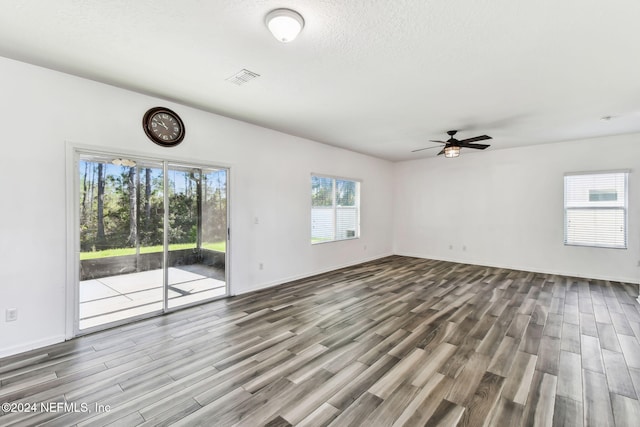 unfurnished living room with wood-type flooring, a textured ceiling, and ceiling fan