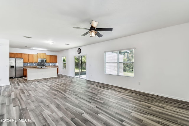 unfurnished living room with light hardwood / wood-style floors and ceiling fan