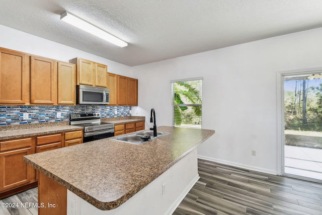 kitchen with a kitchen island with sink, sink, and stainless steel appliances