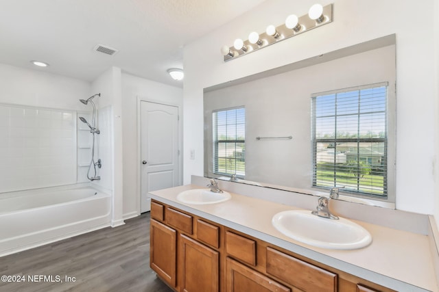 bathroom featuring hardwood / wood-style flooring, tiled shower / bath combo, and vanity