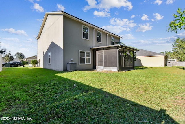 back of property featuring a sunroom, cooling unit, and a lawn