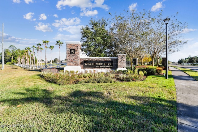 community / neighborhood sign featuring a lawn