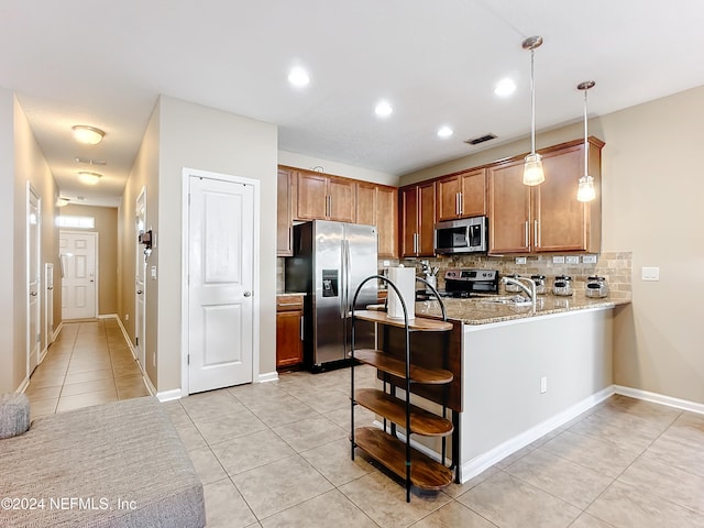 kitchen with sink, backsplash, kitchen peninsula, decorative light fixtures, and appliances with stainless steel finishes