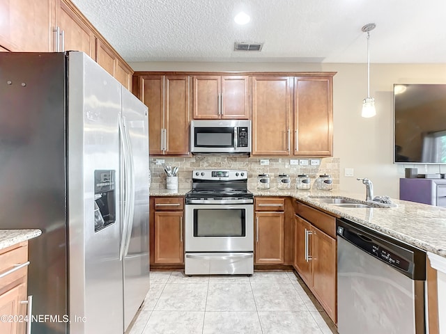 kitchen with sink, decorative backsplash, light tile patterned floors, decorative light fixtures, and stainless steel appliances