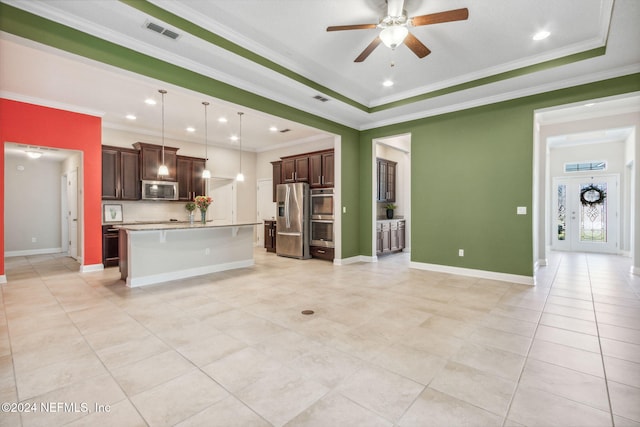 unfurnished living room featuring a tray ceiling, ceiling fan, light tile patterned floors, and ornamental molding