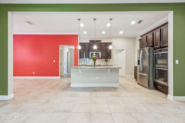 kitchen with dark brown cabinetry, stainless steel appliances, tasteful backsplash, an island with sink, and pendant lighting