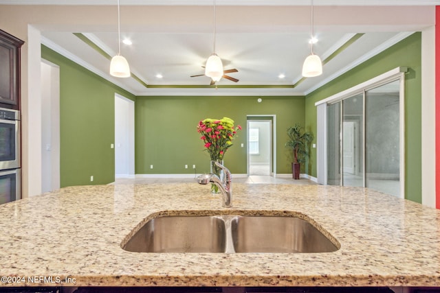 kitchen with decorative light fixtures, ornamental molding, and sink