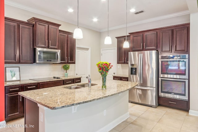 kitchen with a kitchen island with sink, sink, decorative light fixtures, and appliances with stainless steel finishes