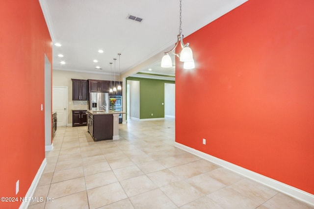 kitchen featuring an inviting chandelier, stainless steel fridge with ice dispenser, crown molding, pendant lighting, and a center island with sink