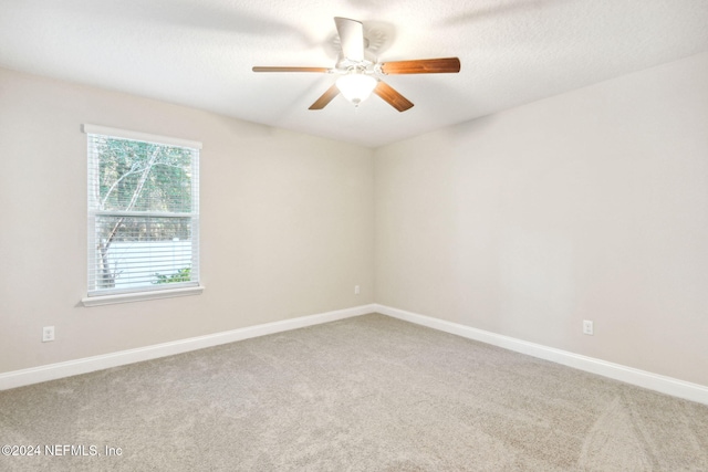 carpeted spare room with a textured ceiling and ceiling fan