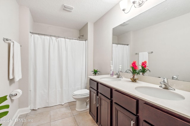 bathroom with tile patterned floors, vanity, toilet, and a textured ceiling