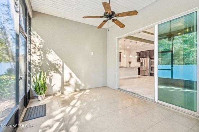 unfurnished sunroom with ceiling fan and wooden ceiling