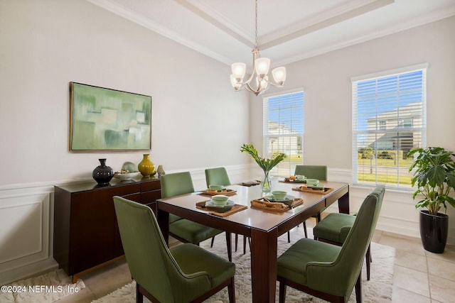 dining space featuring a chandelier, a tray ceiling, ornamental molding, and light tile patterned flooring