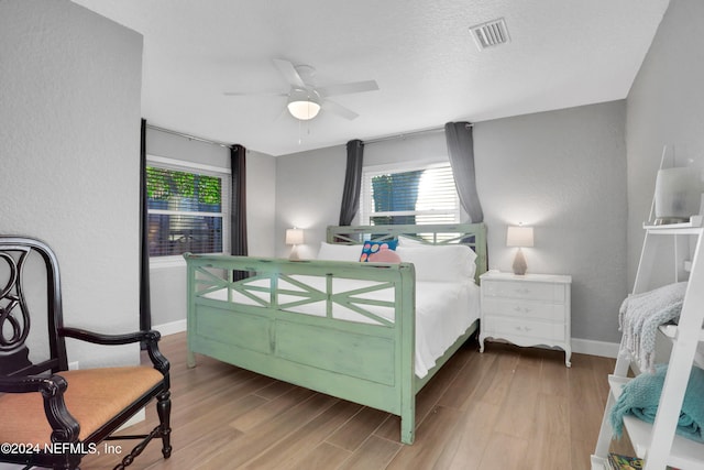 bedroom featuring a textured ceiling, hardwood / wood-style flooring, and ceiling fan