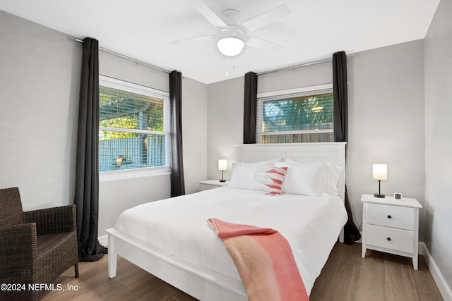 bedroom with dark hardwood / wood-style floors and ceiling fan