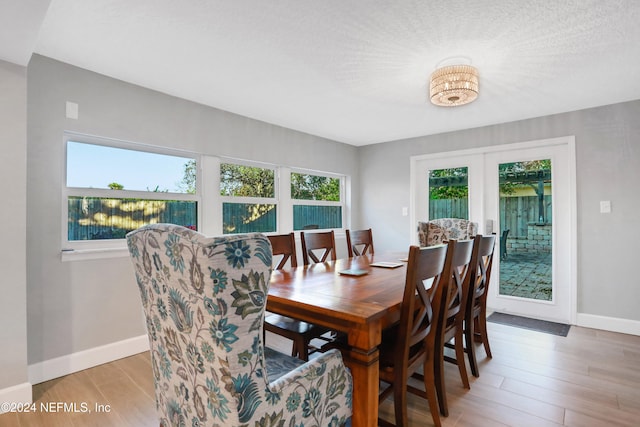 dining room with a textured ceiling and light hardwood / wood-style flooring