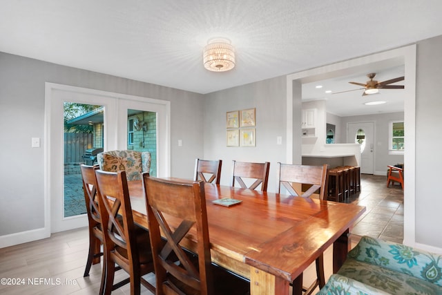 dining area featuring a textured ceiling, ceiling fan with notable chandelier, and light tile patterned flooring