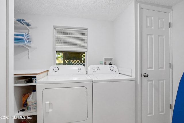 laundry area with washer and clothes dryer and a textured ceiling