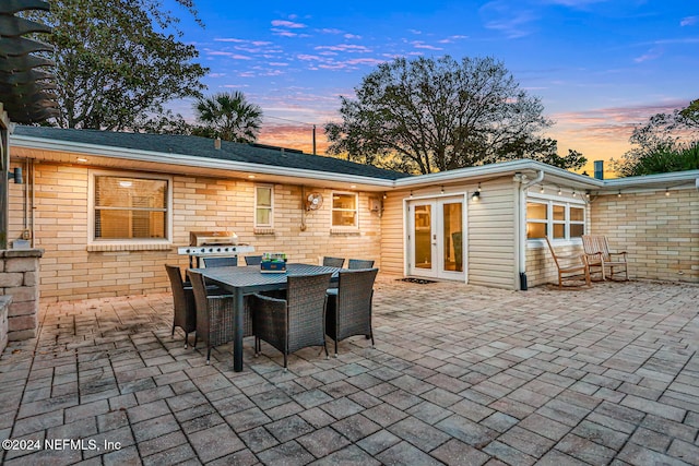 patio terrace at dusk with french doors and area for grilling