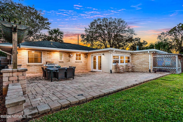 back house at dusk with a patio area