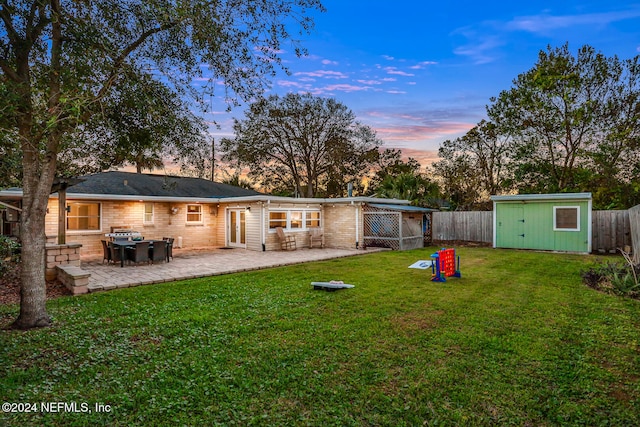 yard at dusk with a patio and a storage shed