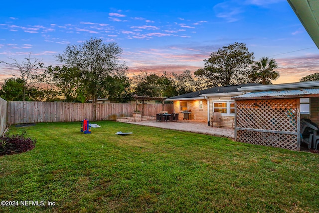 yard at dusk featuring a patio