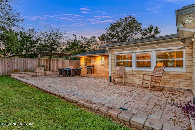 patio terrace at dusk featuring grilling area