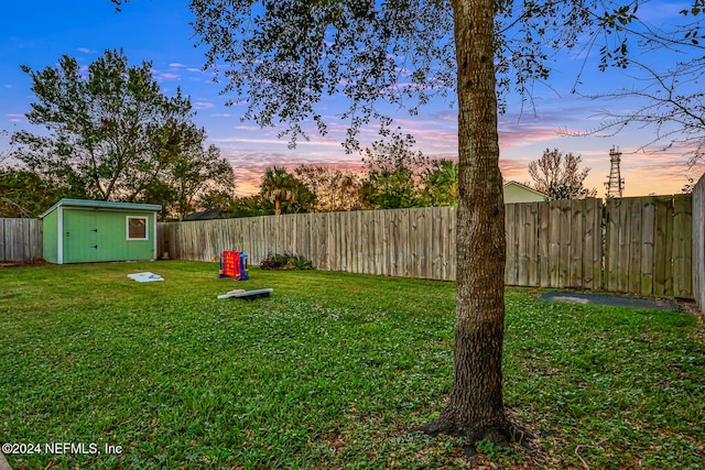 yard at dusk featuring a shed