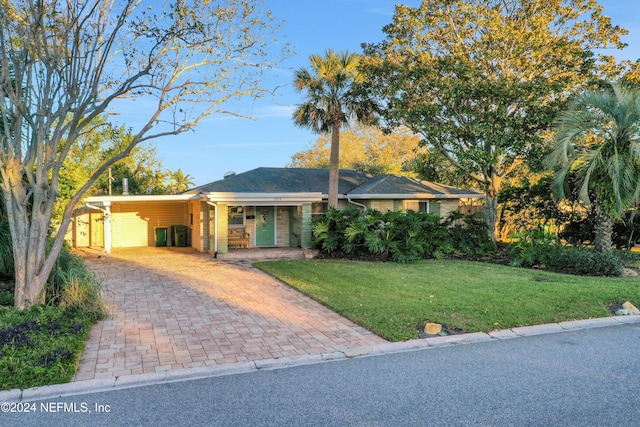 ranch-style house featuring a front lawn and a carport