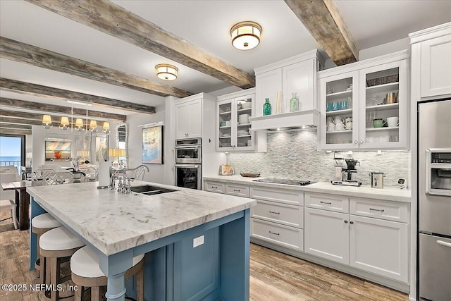 kitchen featuring stainless steel appliances, white cabinetry, beamed ceiling, and sink