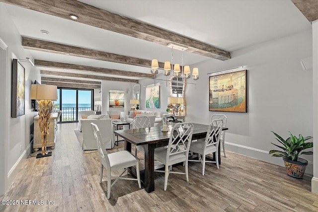 dining room featuring wood-type flooring, a chandelier, and beamed ceiling