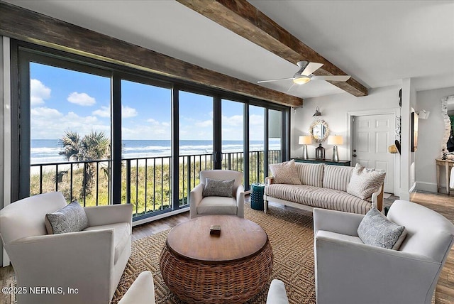 living room with hardwood / wood-style floors, beam ceiling, ceiling fan, and a water view