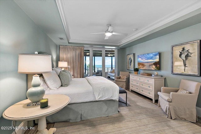 bedroom with ceiling fan, access to outside, crown molding, and a tray ceiling