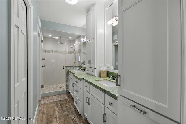 bathroom with hardwood / wood-style flooring, walk in shower, and vanity