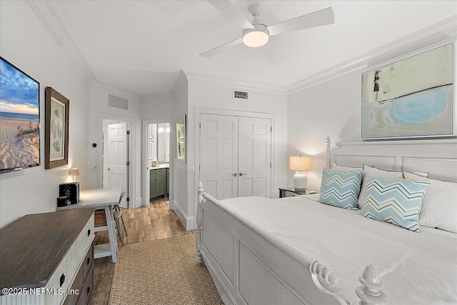 bedroom featuring connected bathroom, a closet, wood-type flooring, ceiling fan, and ornamental molding