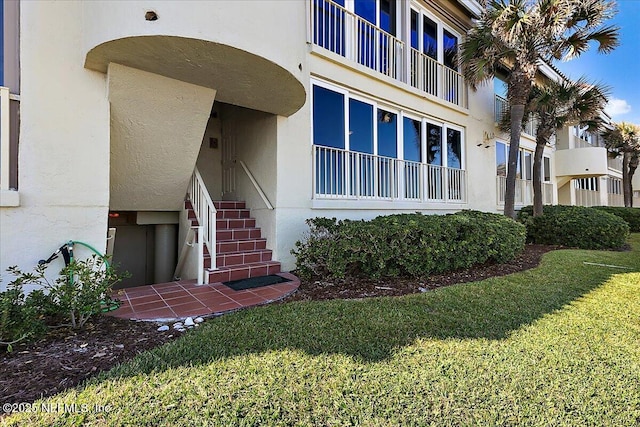 view of exterior entry featuring elevator and a yard