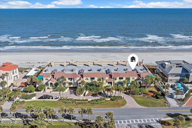 birds eye view of property featuring a beach view and a water view