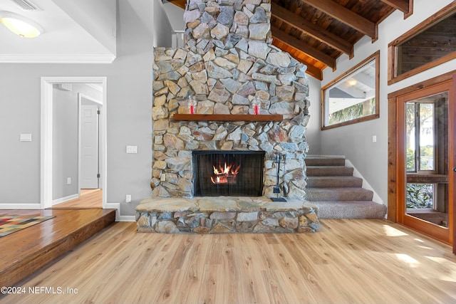 unfurnished living room featuring a fireplace, light hardwood / wood-style flooring, beamed ceiling, and wooden ceiling