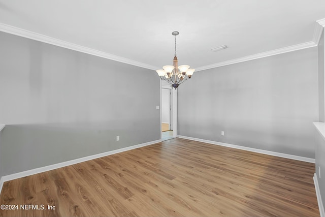 unfurnished room featuring an inviting chandelier, ornamental molding, and light wood-type flooring