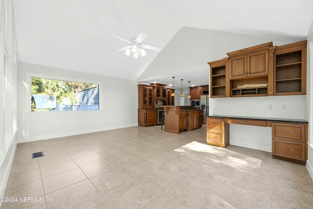 kitchen featuring appliances with stainless steel finishes, ceiling fan, built in desk, high vaulted ceiling, and hanging light fixtures