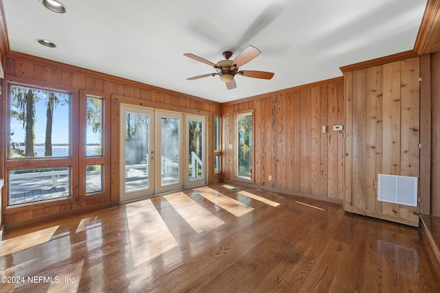 spare room with dark hardwood / wood-style floors, wood walls, crown molding, and french doors