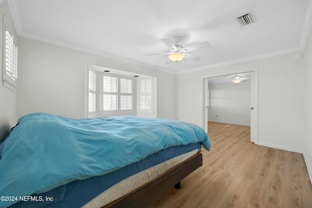 bedroom featuring ceiling fan, light wood-type flooring, crown molding, and a closet